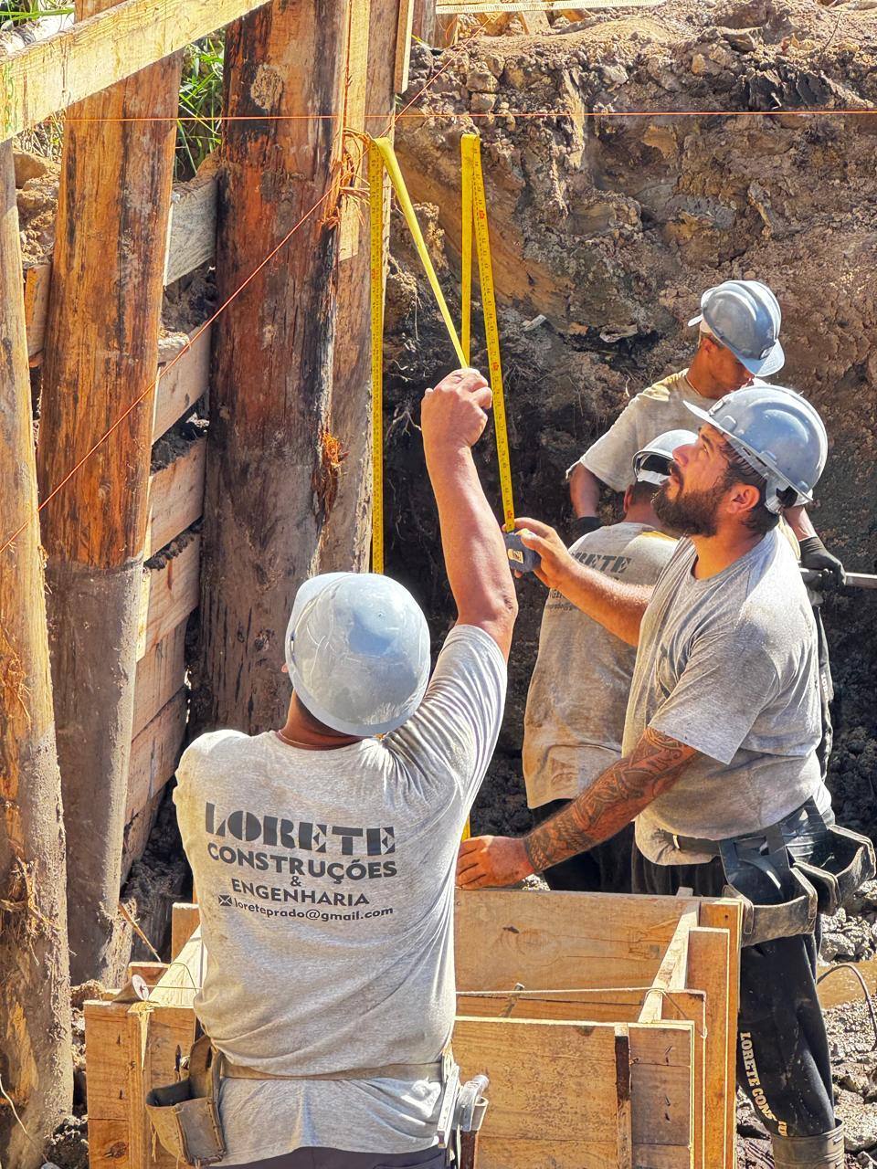 Equipe da Lorete Construções aprumando a forma de um pilar na fundação
